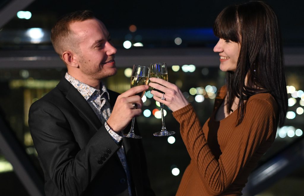 A man and woman clink their wine glasses.