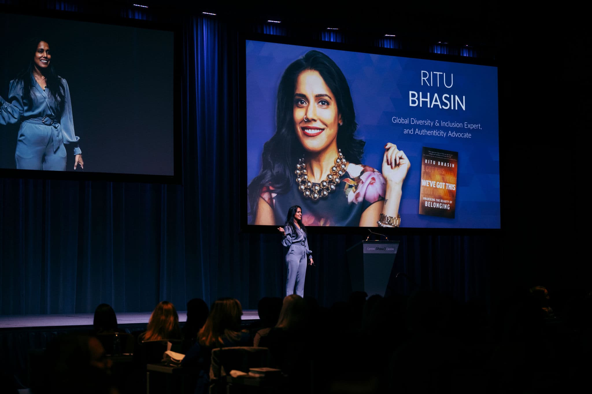 Ritu Bhasin on stage in Canada Hall speaking to the audience